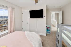 Carpeted bedroom featuring ceiling fan