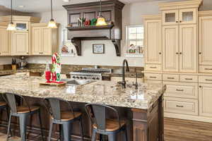 Kitchen featuring cream cabinetry, dark hardwood / wood-style flooring, and hanging light fixtures