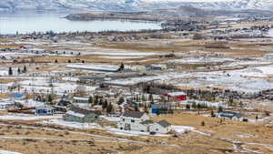 Snowy aerial view featuring a water and mountain view