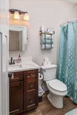 Bathroom featuring vanity, toilet, and wood-type flooring