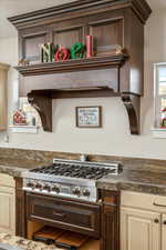 Kitchen featuring stainless steel gas stovetop, dark brown cabinets, and cream cabinets