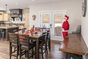 Dining room with dark hardwood / wood-style flooring and french doors