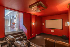 Carpeted cinema room featuring a textured ceiling