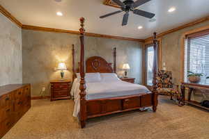 Bedroom with carpet, ceiling fan, and crown molding