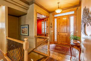 Foyer featuring crown molding and hardwood / wood-style flooring