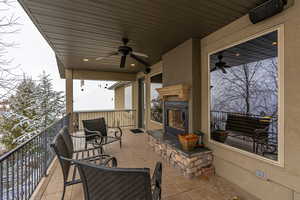 View of patio featuring ceiling fan and a balcony