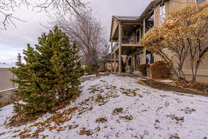 Snowy yard featuring a balcony