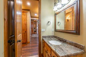 Bathroom featuring crown molding, hardwood / wood-style floors, and vanity