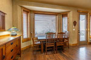 Dining area with a healthy amount of sunlight and dark hardwood / wood-style flooring