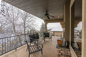 View of patio with ceiling fan and a balcony