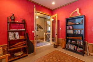 Interior space with carpet flooring, crown molding, and wooden walls