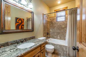 Full bathroom featuring vanity, toilet, and shower / bath combo with shower curtain