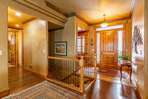 Entrance foyer with hardwood / wood-style floors and ornamental molding