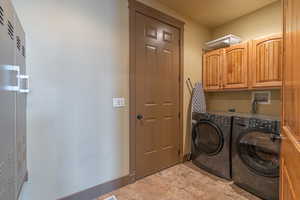 Washroom with cabinets and washing machine and clothes dryer