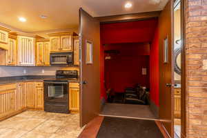 Kitchen with light tile patterned floors and black appliances