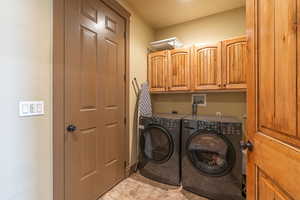 Laundry room featuring cabinets and independent washer and dryer