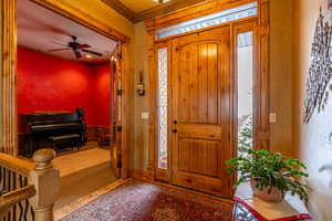 Foyer featuring ceiling fan and crown molding