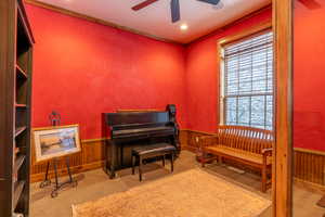 Living area with light colored carpet, ceiling fan, and ornamental molding