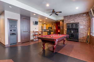 Game room featuring ceiling fan, brick wall, and pool table