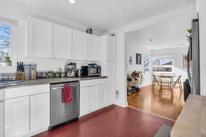 Kitchen featuring white cabinets, stainless steel appliances, and a wealth of natural light