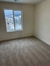 Unfurnished room with a wealth of natural light and carpet floors