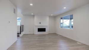 Unfurnished living room featuring a fireplace and light hardwood / wood-style floors