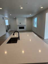 Kitchen with a textured ceiling, dark hardwood / wood-style floors, a healthy amount of sunlight, and sink