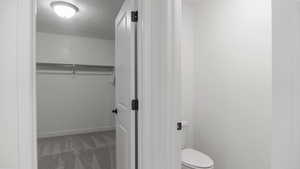 Bathroom with a textured ceiling and toilet