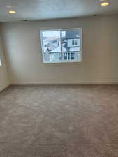 Carpeted empty room with a textured ceiling