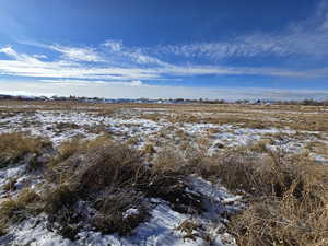 View of snow covered land featuring a rural view