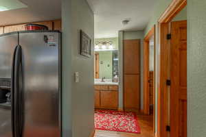 Hall with hardwood / wood-style floors, sink, and a textured ceiling