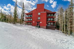 View of snow covered back of property