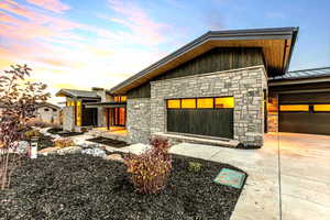 View of front of home featuring a standing seam roof, stone siding, and a metal roof
