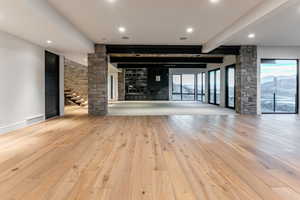 Living room and pool table area featuring a premium fireplace, a mountain view, recessed lighting, ceiling fan, and a wood ceiling with exposed beams