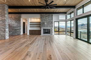 Living room with Jordanelle and Deer Valley Views, a fireplace, light wood finished floors, a wooden ceiling with exposed beams, and natural light