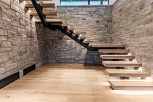 Staircase with wood flooring and undertone lighting.