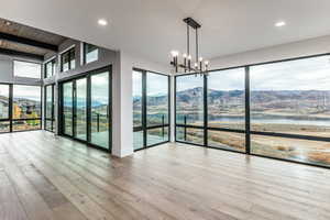 Living room and Dining room with Jordanelle and Deer Valley Views, a fireplace, light wood finished floors, a wooden ceiling with exposed beams, and natural light
