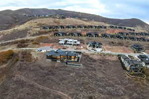 Aerial view of property and surrounding area with mountains and nearby suburban area