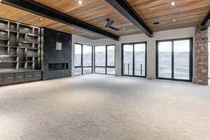 Living room featuring a premium fireplace, a mountain view, recessed lighting, ceiling fan, and a wood ceiling with exposed beams