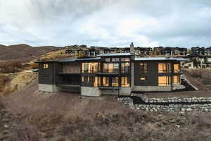 Rear view of property with a balcony and a metal roof