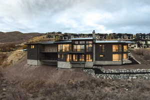 Rear view of house with a balcony and a metal roof