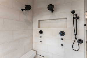 Primary Bathroom featuring double vanity, a chandelier, walk in shower, steam/wetroom, stand alone tub and a spacious closet with a stackable washer/dryer.