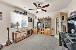 Carpeted home office featuring ceiling fan