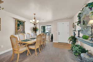 Dining room featuring a notable chandelier, carpet floors, and a textured ceiling