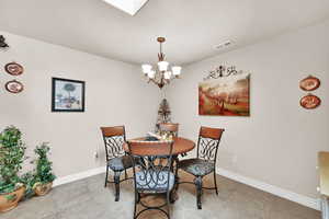 Dining room featuring tile patterned flooring and an inviting chandelier