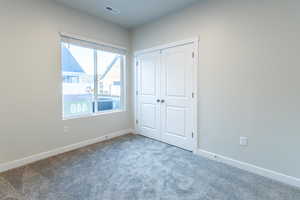 Unfurnished bedroom featuring carpet and a closet