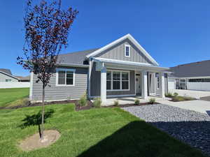 View of front of house featuring a garage, covered porch, and a front yard