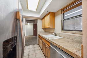 Kitchen featuring sink, appliances with stainless steel finishes, and light carpet