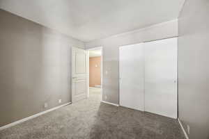 Unfurnished bedroom featuring carpet flooring and a closet