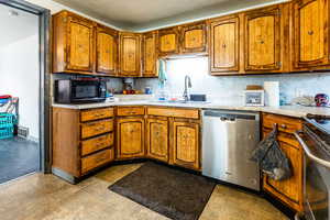 Kitchen with sink, stainless steel appliances, and tasteful backsplash